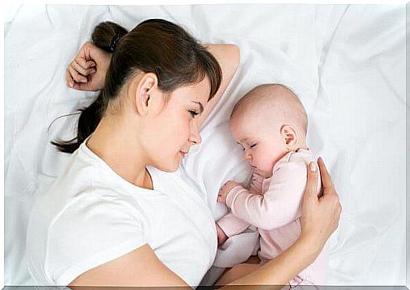 Newborn baby with mother on the bed