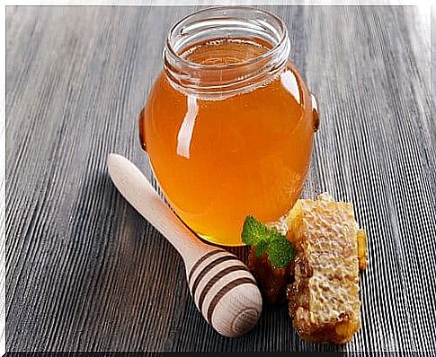 Jar with honey and honey spreader