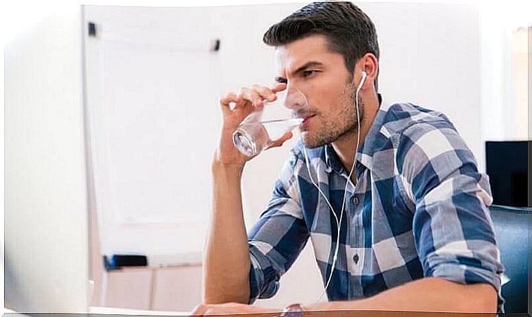 Boy at the computer drinking water