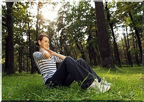 Woman performs exercises in the meadow