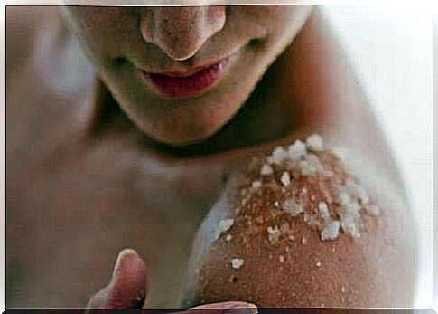 Woman exfoliates her shoulders with salt