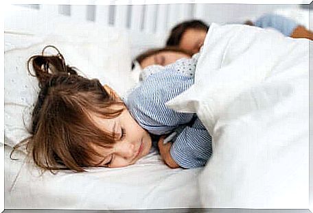 Little girl sleeping with parents.