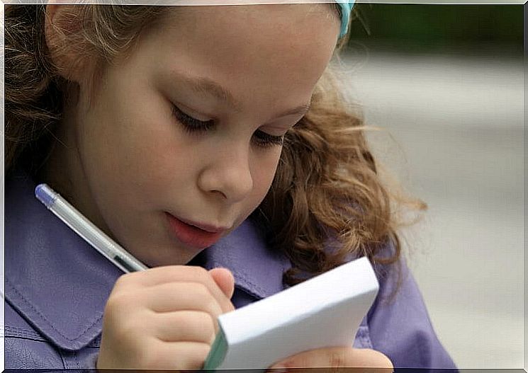 Little girl writing on a notepad spelling exercises