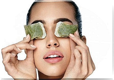 Woman applying tea bags to treat eye pain.