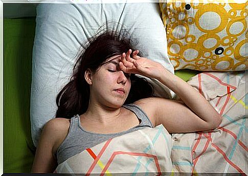 Girl in bed with hand on forehead