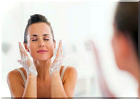 Young woman washes her face